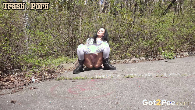 Brunette enjoying pissing outside and watching it