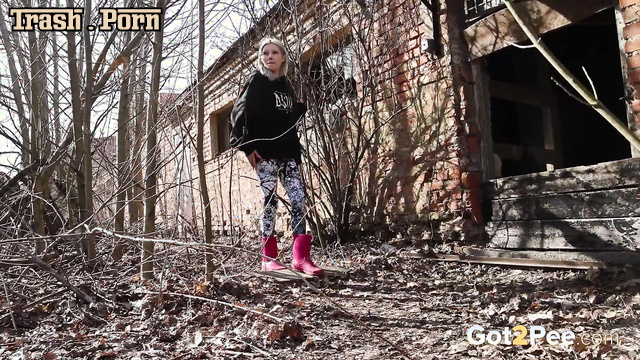 Cute and pretty blonde peeing outdoors in the country